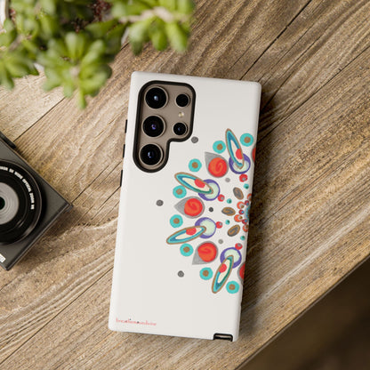 Phone case with colorful design on a wooden surface next to a camera and plant