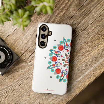 Phone case with colorful design on a wooden surface next to a camera and plant