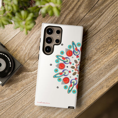 Phone case with colorful design on a wooden surface next to a camera and plant